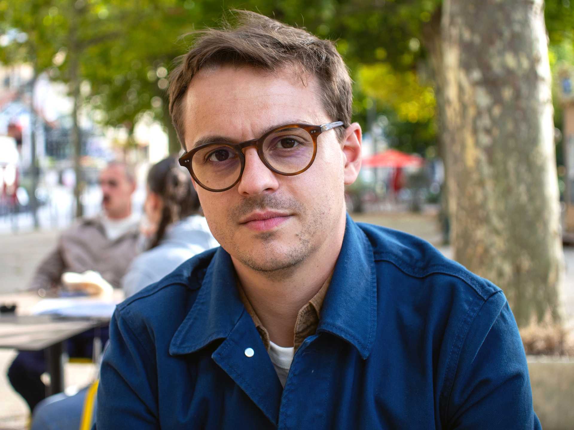A man in glasses and a blue collared shirt.