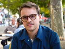 A man in glasses and a blue collared shirt.